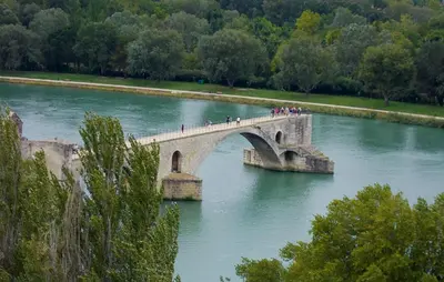 a group of people crossing a bridge over a river at Frutiere 1 in Caromb