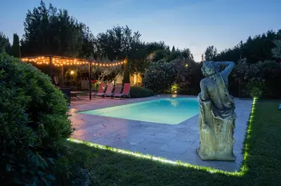 a statue next to a swimming pool in a yard at Mas des Agranas in Sénas