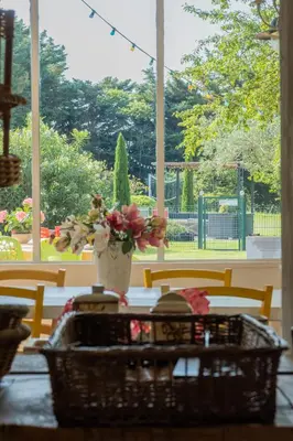 a table with a basket of flowers and a vase at Mas des Agranas in Sénas