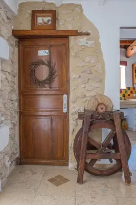 a wooden door with a wooden wheel in front of it at Mas des Agranas in Sénas