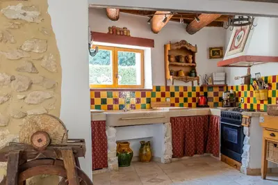 a kitchen with colorful tiles on the walls and a sink at Mas des Agranas in Sénas