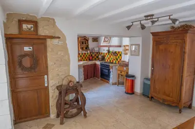a kitchen with a stone wall and a table in it at Mas des Agranas in Sénas