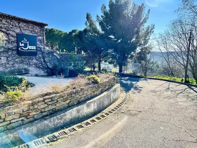 a stone wall next to a road with a sign at Lou Miradou 2 - Vieux village médiéval, Cosy, Clim, 2 personnes in Miramas