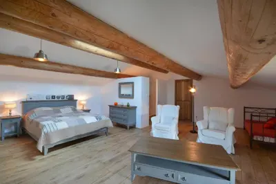a bedroom with a bed and two chairs and a table at Le domaine de Villemus chambre d'hote in Jouques
