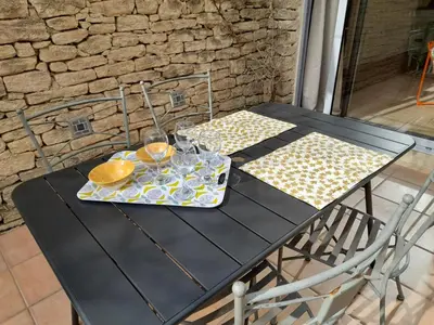 a black table with a plate of food and wine glasses at Le Mazet des Jasmins in Gordes