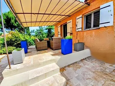 an outdoor patio with furniture and an umbrella at Chez Mylène et Jean in Bédoin