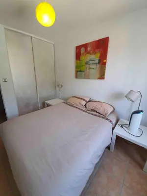 a bedroom with a bed and a lamp on a table at Chez Mylène et Jean in Bédoin