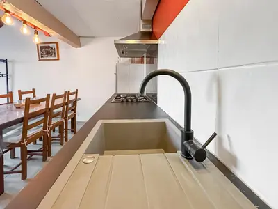 a kitchen with a sink and a table with chairs at Maison provençale de charme au cœur du Luberon in Saint-Saturnin-les-Apt