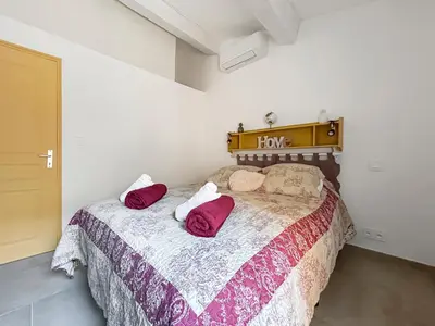 a bedroom with a bed with two pillows on it at Maison provençale de charme au cœur du Luberon in Saint-Saturnin-les-Apt