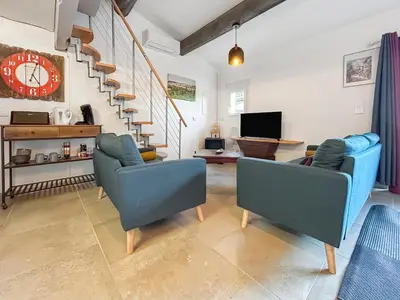 a living room with two blue chairs and a staircase at Maison provençale de charme au cœur du Luberon in Saint-Saturnin-les-Apt