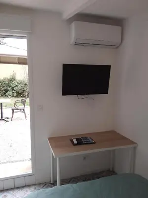 a room with a tv on a wall with a table at Le passé temps in Éguilles