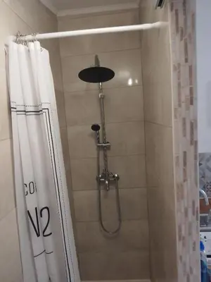 a shower with a shower curtain in a bathroom at Le passé temps in Éguilles