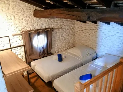 a bedroom with two beds in a stone walled room at Gîte Le Provence Spacieux 100m2 in Saumane-de-Vaucluse