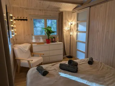 a bedroom with a bed and a chair and a window at Le Chalet Bleu - jacuzzi in Aix-en-Provence
