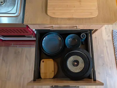 a drawer in a kitchen with bowls and plates at Le Chalet Bleu - jacuzzi in Aix-en-Provence