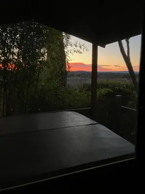 a view of a table with a sunset in the background at Le Chalet Bleu - jacuzzi in Aix-en-Provence