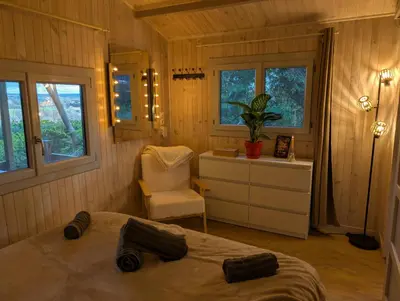 a bedroom with a bed and a chair and windows at Le Chalet Bleu - jacuzzi in Aix-en-Provence