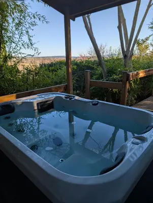a jacuzzi tub on a deck with a view at Le Chalet Bleu - jacuzzi in Aix-en-Provence