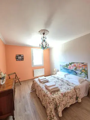 a bedroom with a bed with a table and a chandelier at Mas Provençal with Swimming Pool & Air Conditioning in Rustrel