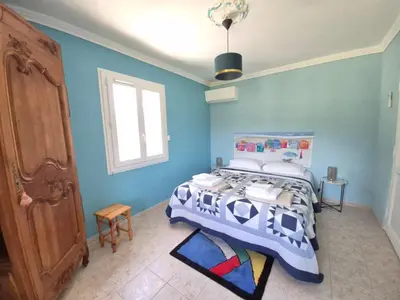 a bedroom with a bed with a blue wall at Mas Provençal with Swimming Pool & Air Conditioning in Rustrel