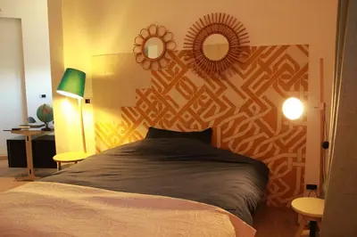 a bedroom with a bed and two mirrors on the wall at Maison aix en Provence piscine in Aix-en-Provence