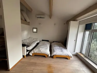 two beds in a room with a window at Maison aix en Provence piscine in Aix-en-Provence