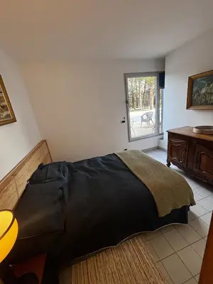 a bedroom with a bed and a table and a window at Maison aix en Provence piscine in Aix-en-Provence