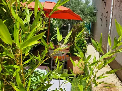 a red umbrella sitting next to some green plants at Espace Ki-Zen in Pélissanne