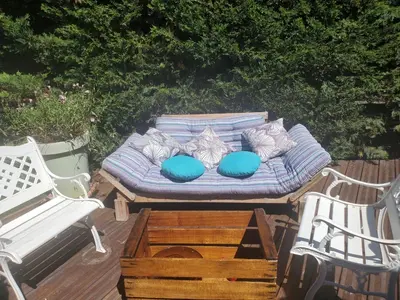 a couch sitting on a wooden deck with two chairs at Espace Ki-Zen in Pélissanne