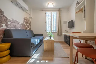 a living room with a blue couch and a table at Studio Climatisé rdc plein centre in Aix-en-Provence