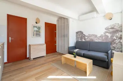 a living room with a blue couch and a table at Studio climatisé plein centre ville 1er ETAGE in Aix-en-Provence