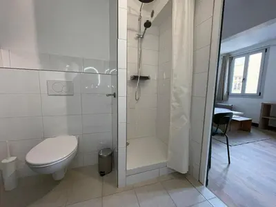 a white bathroom with a toilet and a shower at Studio climatisé plein centre ville 1er ETAGE in Aix-en-Provence