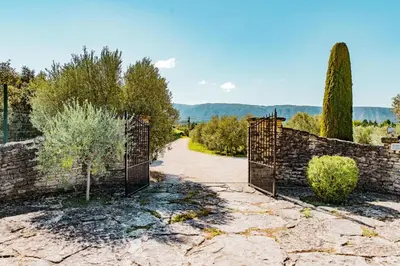a living room with a table and a dining room at Maison de charme avec piscine chauffée à Gordes in Gordes