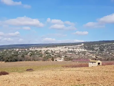 a field with a city in the distance at Lou pichoun studio au coeur d'un village provençal in Gargas