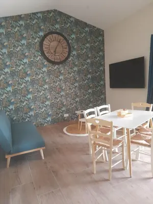 a dining room with a table and chairs and a clock at Gîte La Chouette Hulotte classé 3 étoiles Spa, Mt Ventoux, Parc Spirou in Flassan
