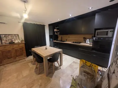a kitchen with a wooden table and a microwave at Maison A proximité d'Avignon et site touristique in Avignon