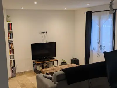 a living room with a couch and a flat screen tv at Maison A proximité d'Avignon et site touristique in Avignon