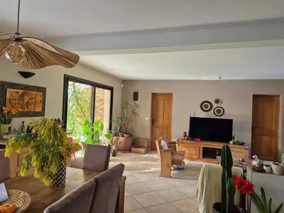 a living room with a table and a tv at Villa 170m2 avec piscine près d Aix en provence 7 couchages in Éguilles