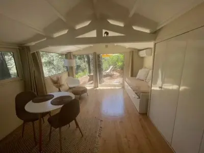 a living room with a table and chairs and a couch at Le Charmeur - Le Chalet Attrape-Coeur in Aix-en-Provence