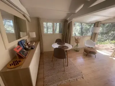 a living room with a table and chairs and windows at Le Charmeur - Le Chalet Attrape-Coeur in Aix-en-Provence