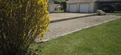 a yard with a gravel driveway with a garage at Charming villa with a pool in Cadenet