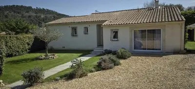 a small white house with a garden in front of it at Charming villa with a pool in Cadenet