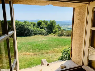 an open window with a view of a field at Provencal farmhouse in Luberon's heart with pool in La Bastide-des-Jourdans