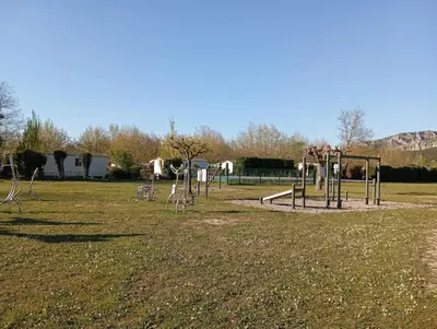 an empty park with a playground with a swing set at Mobil-Home Provence in Cheval-Blanc