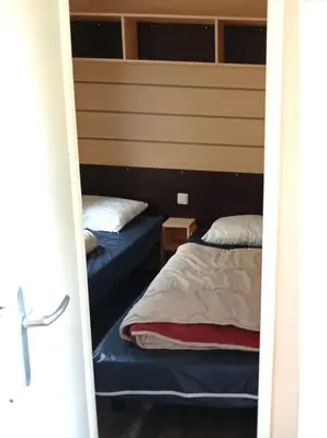 two beds in a room with a door open at Mobil-Home Provence in Cheval-Blanc