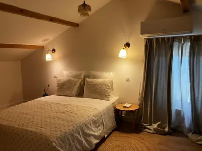 a bedroom with a white bed and a table at MaisonAdèle in Caromb