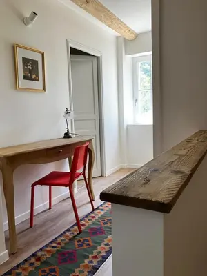 a room with a desk and a red chair and a table at MaisonAdèle in Caromb