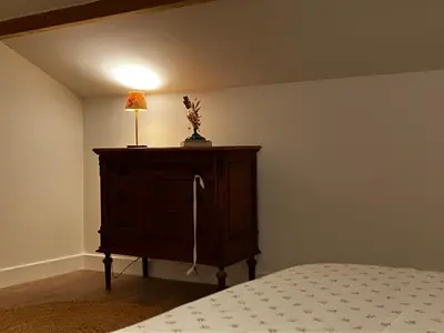 a bedroom with a bed and a dresser with a lamp at MaisonAdèle in Caromb