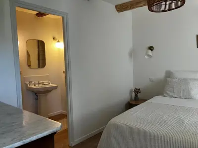 a white bedroom with a bed and a sink at MaisonAdèle in Caromb