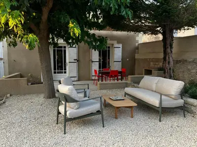 a patio with two chairs and a couch and a table at MaisonAdèle in Caromb